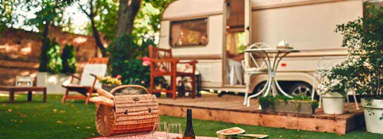 Wohnwagen mit Terrasse und davor liegendem Picknick-Platz