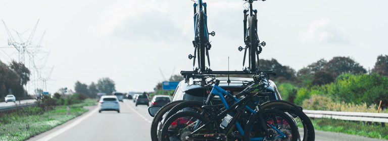 Auto mit Fahrradträgern auf dem Dach und dem Heck