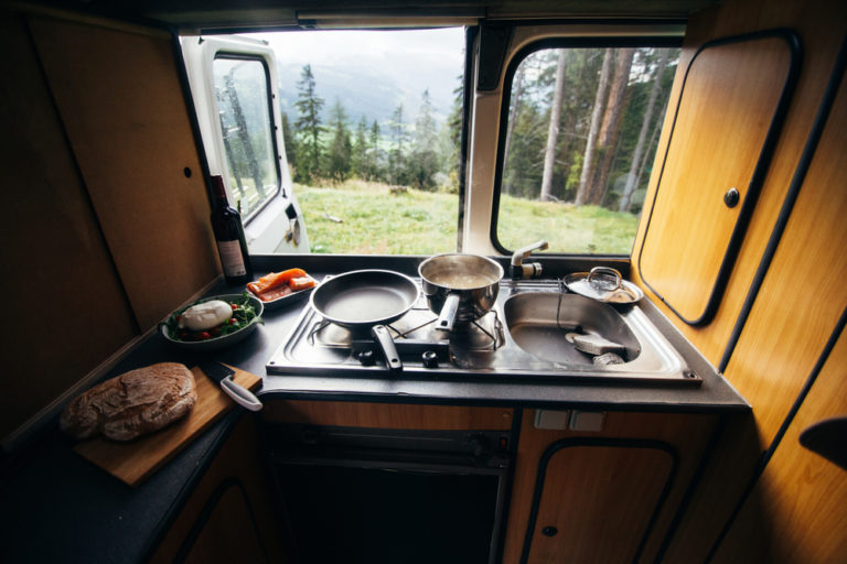 Eine Küche in einem Camper mit Ausblick Richtung Wald